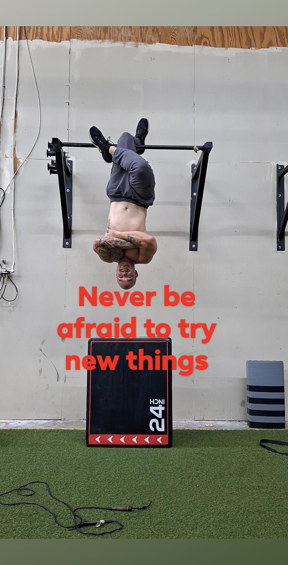 Devon Packett hanging upside down from a pull-up bar